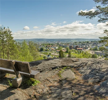 Bilde av en benk på et fjell, med utsikt over Strømmen