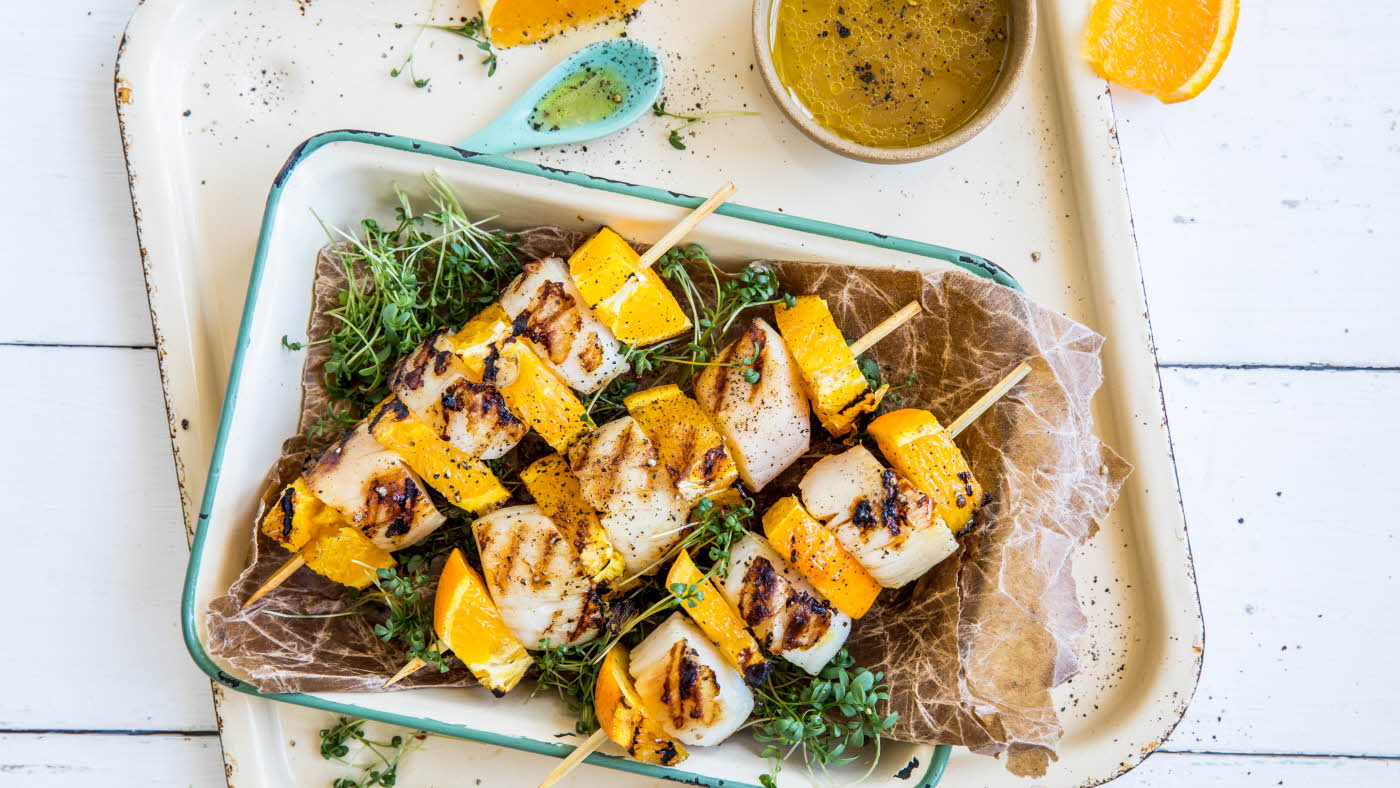 Grillspyd med kamskjell og appelsin i en ildfast form