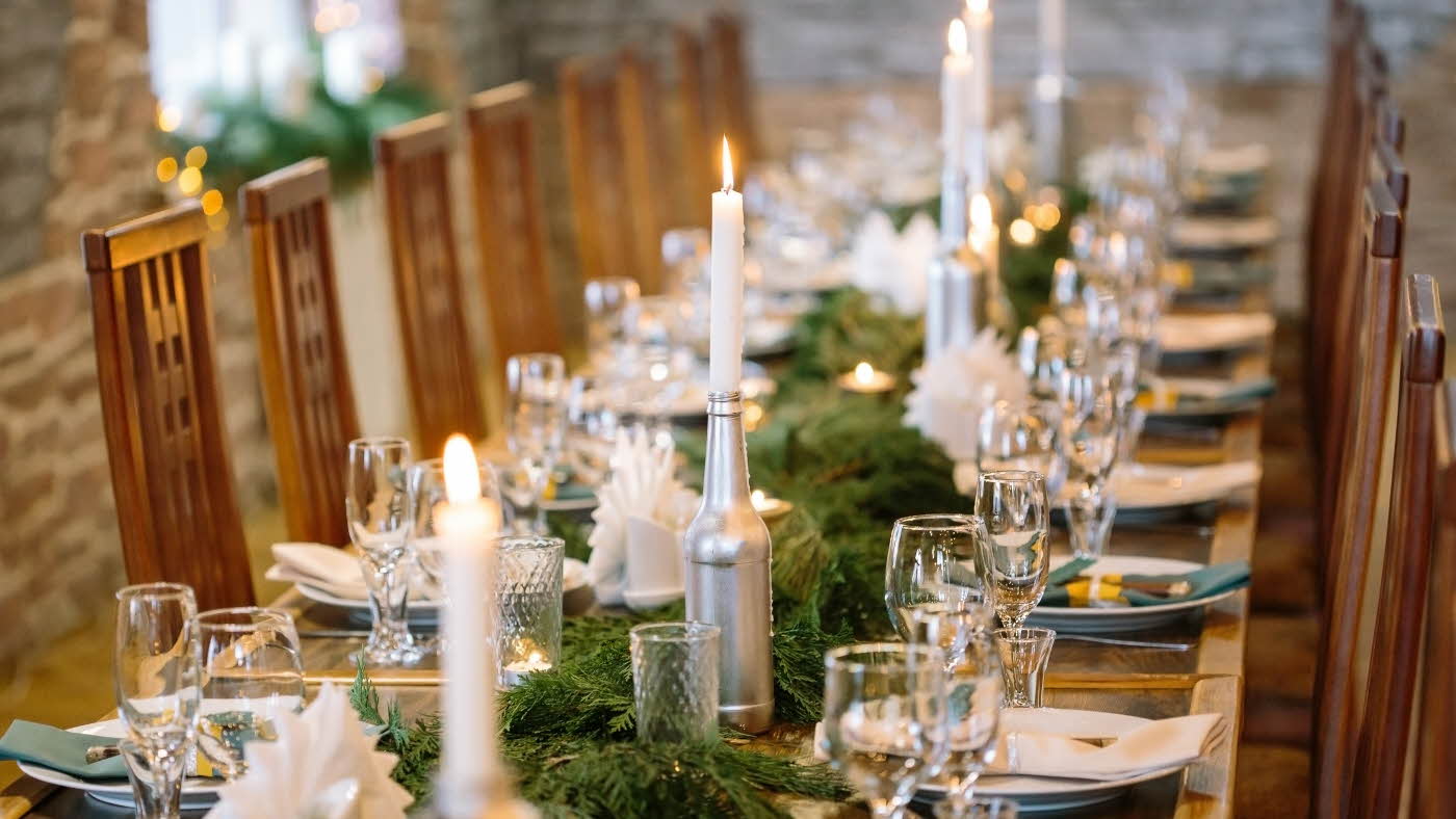 Langbord med grønn dekorasjon og stearinlys