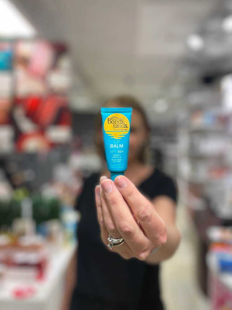 Dame som holder lip balm med solfaktor