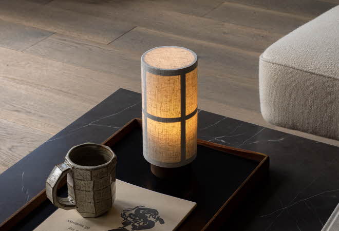 Bordlampe på stuebord med kopp og blader.
