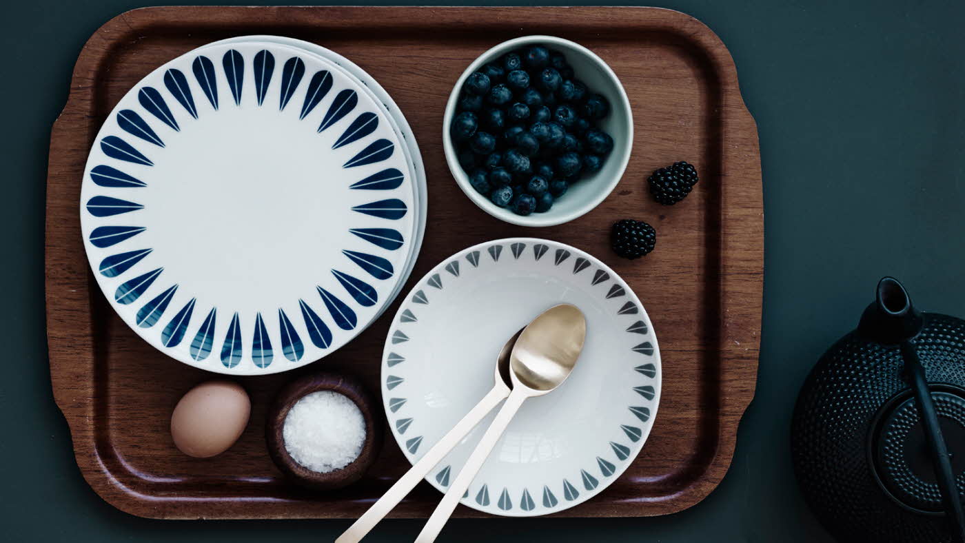 Frokostfat med tallerker, blåbær, egg og salt