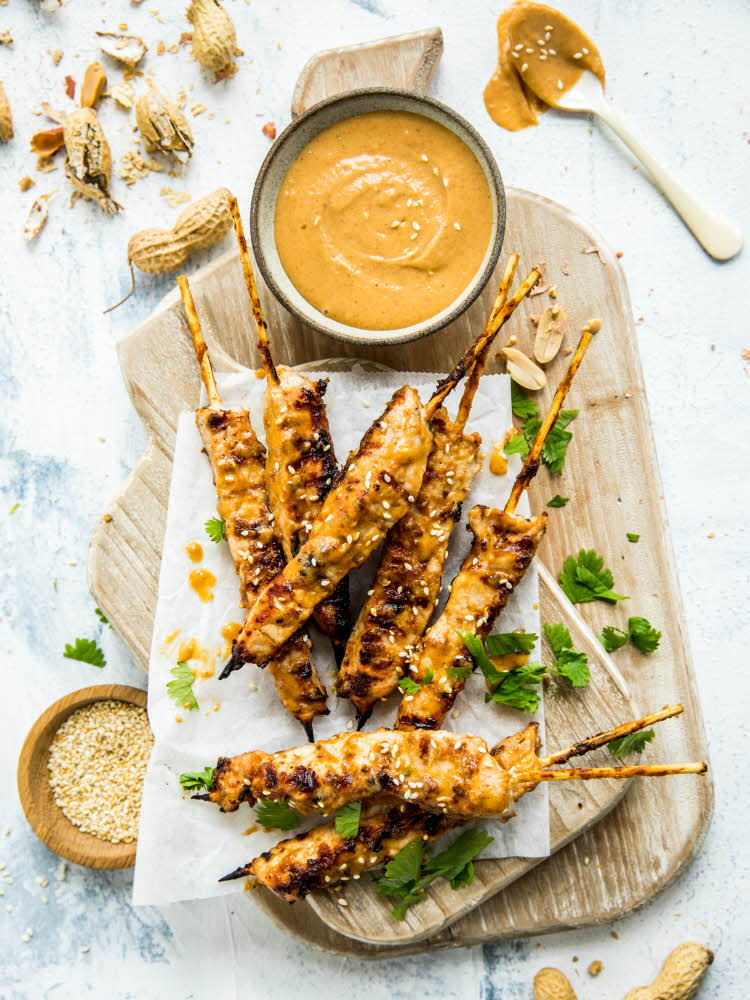 Kyllingsatay-spyd med peanøttsaus ved siden på trefjøl