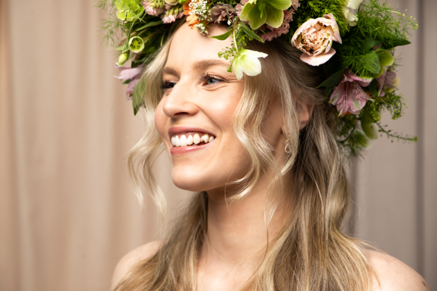 En kvinne med blondt hår og blomsterpynt i håret