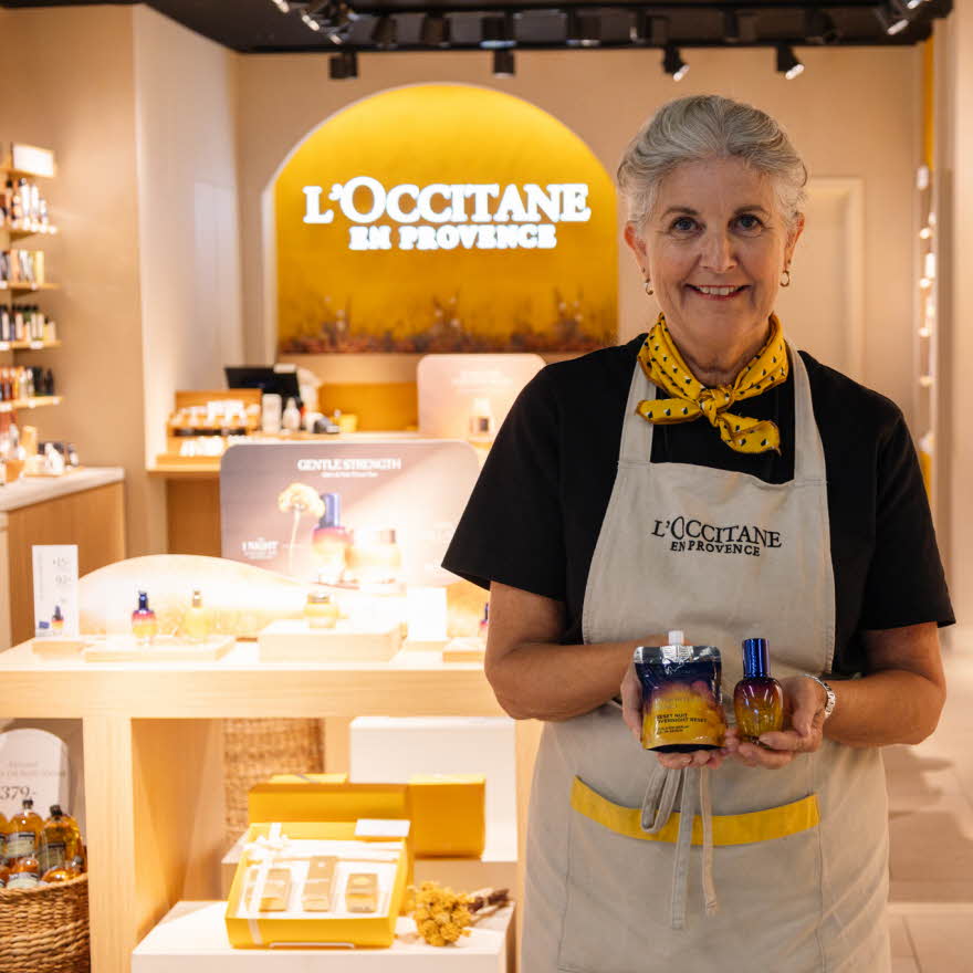 Dame fra L'Occitane viser frem produkter