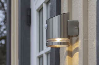 En solcellelampe som er montert ute på et hus