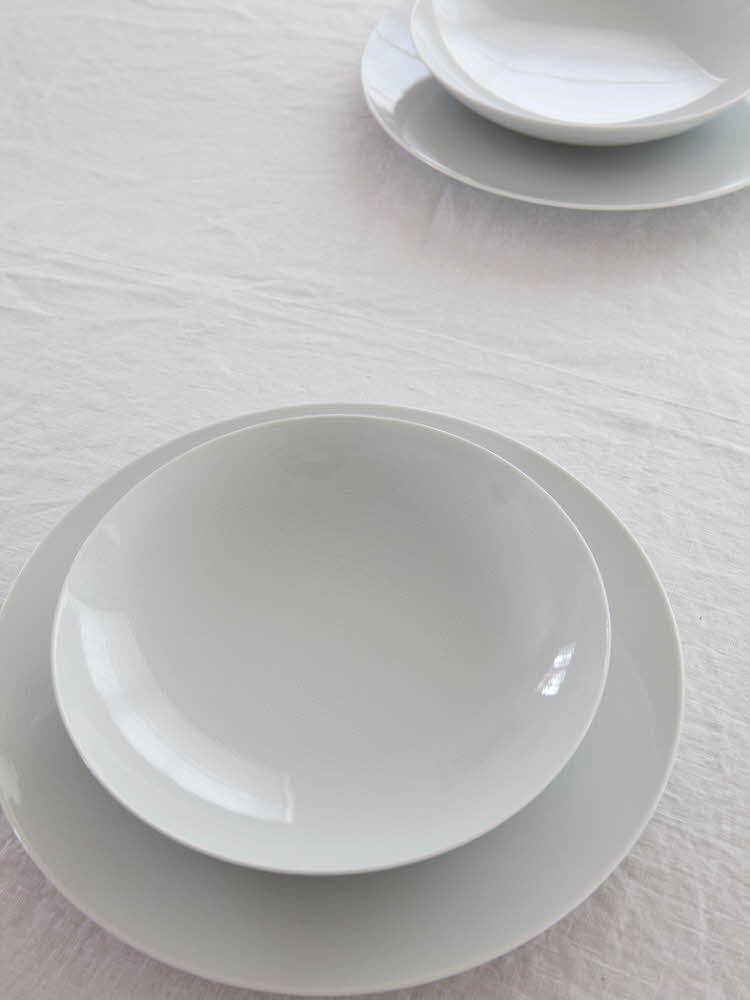 Steg 5 - bord dekket med fire hvite tallerkener Steg 2 - Bord dekket med fire tallerkener og blått menykort