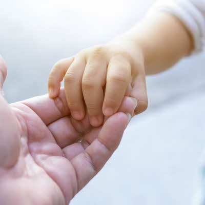 et barnehånd som holder i en voksen hånd