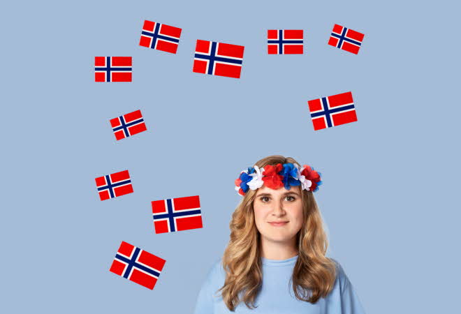 En person med blomsterkrans på hodet, omringet av norske flagg.
