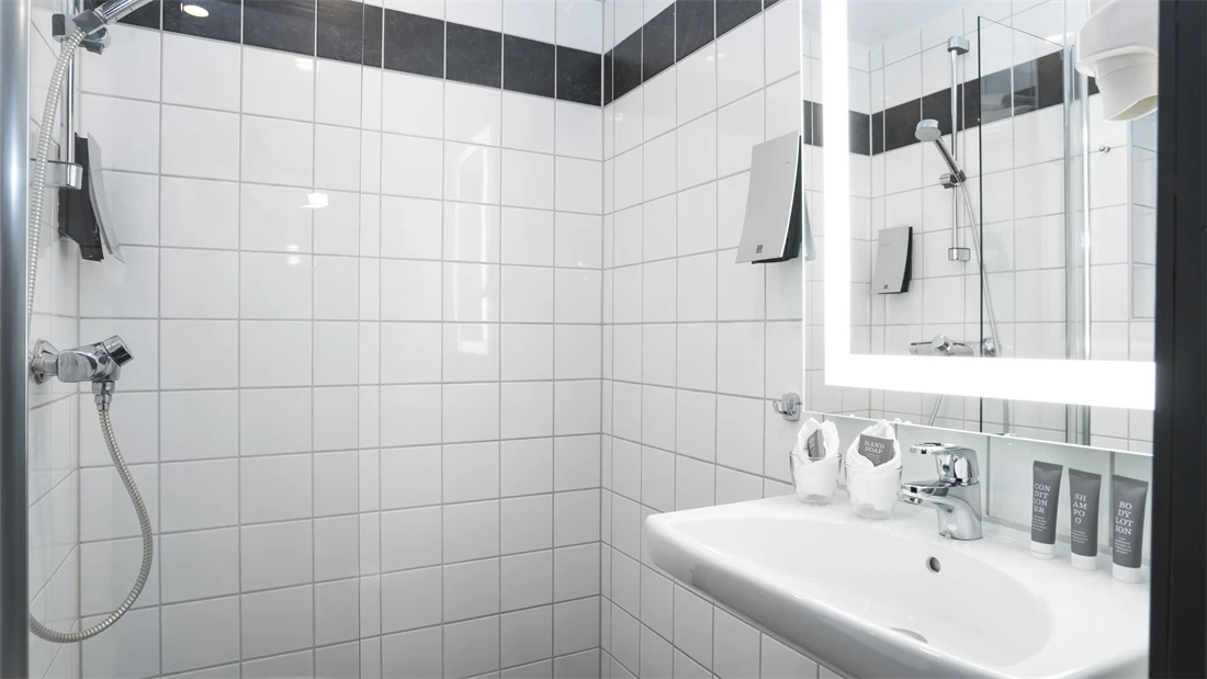 Bad med dusj, speil og vask på Thon Hotel Europa i Oslo sentrum rett ved Slottsparken