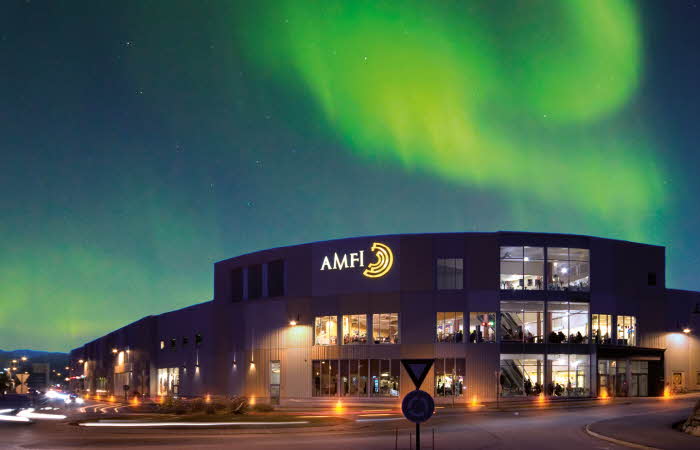 Fasadebilde med nordlys om natten av Amfi Finnsnes