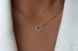 Nærbildet av halsen til en kvinne som har på et smykke med hjerte anheng