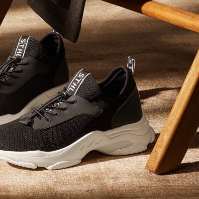 Svarte sko med lisser på gulvet