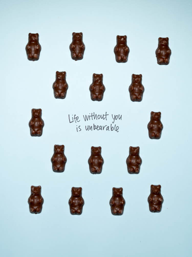 16 brune sjokolade bamsemums ligger på en lysblå bakgrunn. I midten er det skrevet med sort tusj " Life without you is unbearable" En hel og en halv pære som ligger på turkis bakgrunn. På den ene pæren er det skrevet med sort tusj "We make a great pear" 