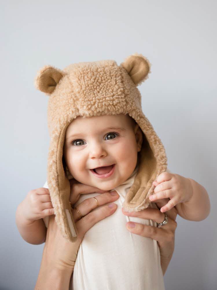 Smilende baby med brun bamselue