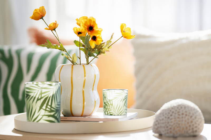 Hvit vase med gule blomster