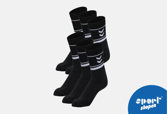 Seks svarte sokker med hvite striper og chevron-mønster.