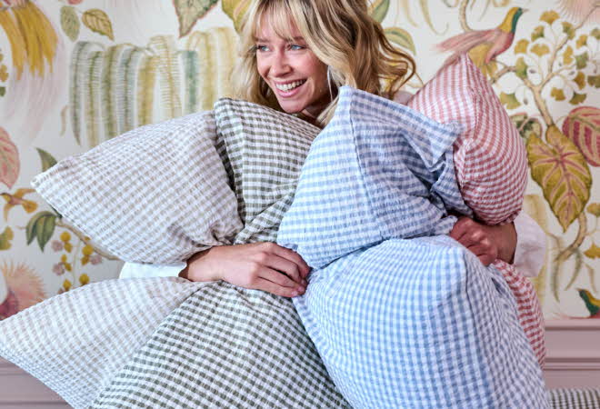 Dame holder flere puter med rutete krepp-trekk i blått, grønt og rosa.