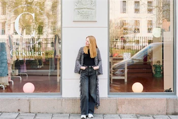 Dame poserer utenfor bruktbutikk i Oslo