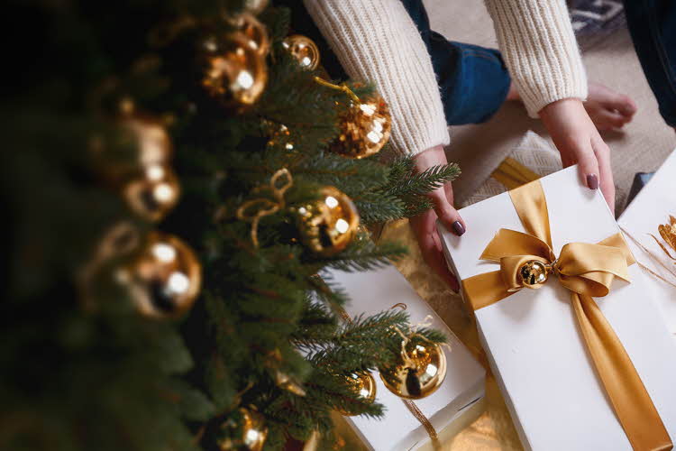 Person henter pakke under juletre