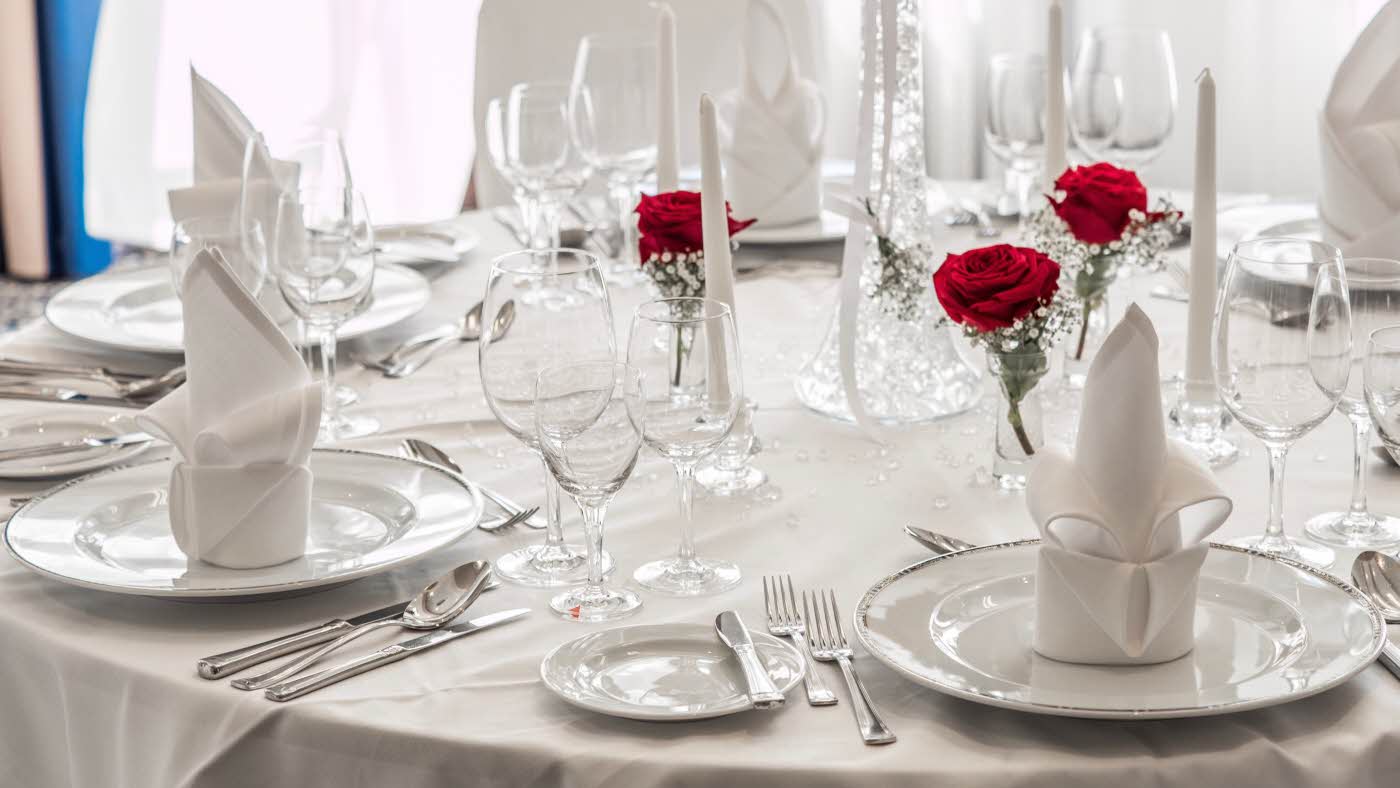 Rundbord med hvit dekorasjon og røde roser
