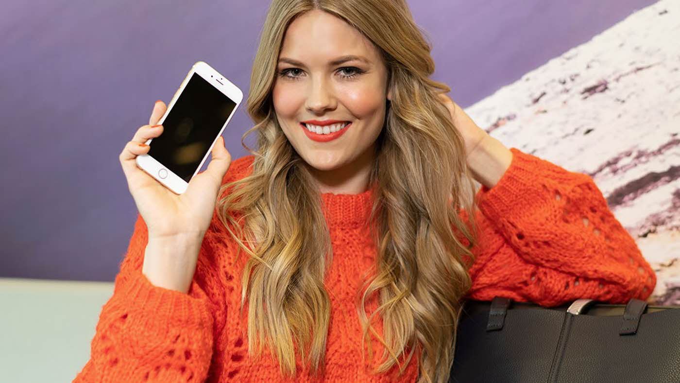 Dame holder smartphone i hånden
