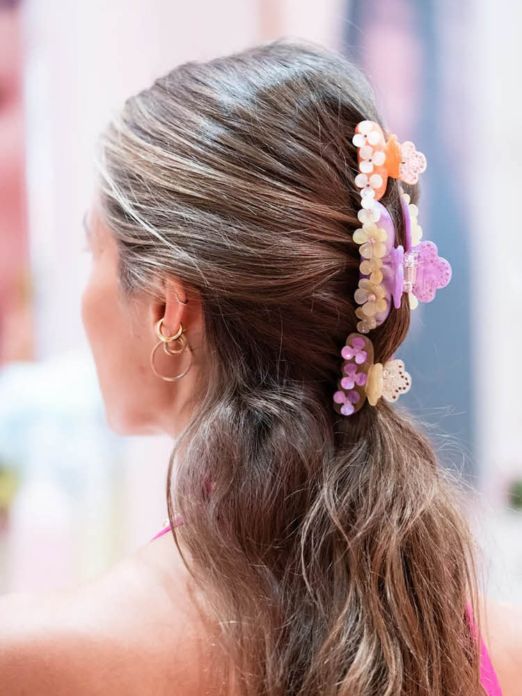 Bakhodet til ung kvinne med tre dekorative hårklyper i håret