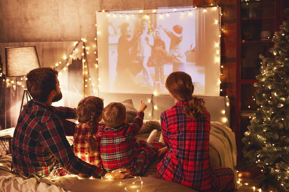 to barn, en far og mor som ser på hjemmekino