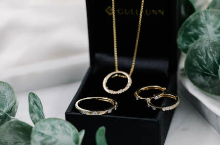 En smykkeboks med et smykke, to øredobber og en ring med diamanter