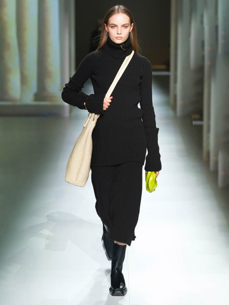 Catwalk bilde av modell ikledd sorte klær med limegrønn detalj