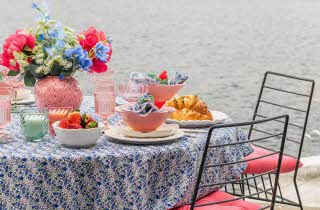 Fargerikt bord dekket til mat med vase med blomster