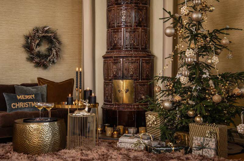 stue dekorert i juletema med juletre, pynteputer, julegaver, stearinlys