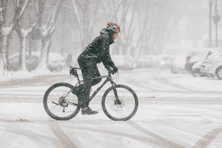 Person på sykkel i urbant snølandskap