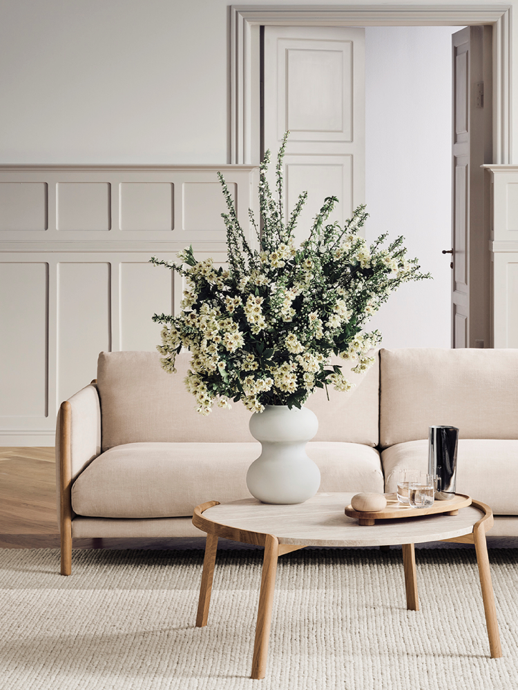 Stua med sofa og bord med vase med blomster