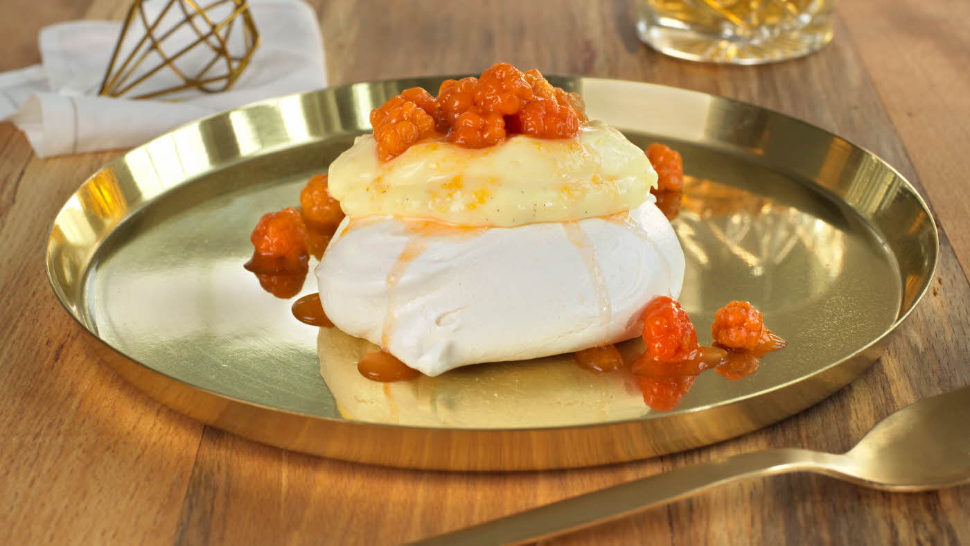 Minipavlova toppet med eggekrem og oransje multer på et gullfat