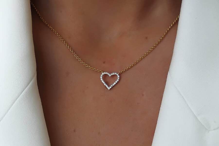 Nærbildet av halsen til en kvinne som har på et smykke med hjerte anheng