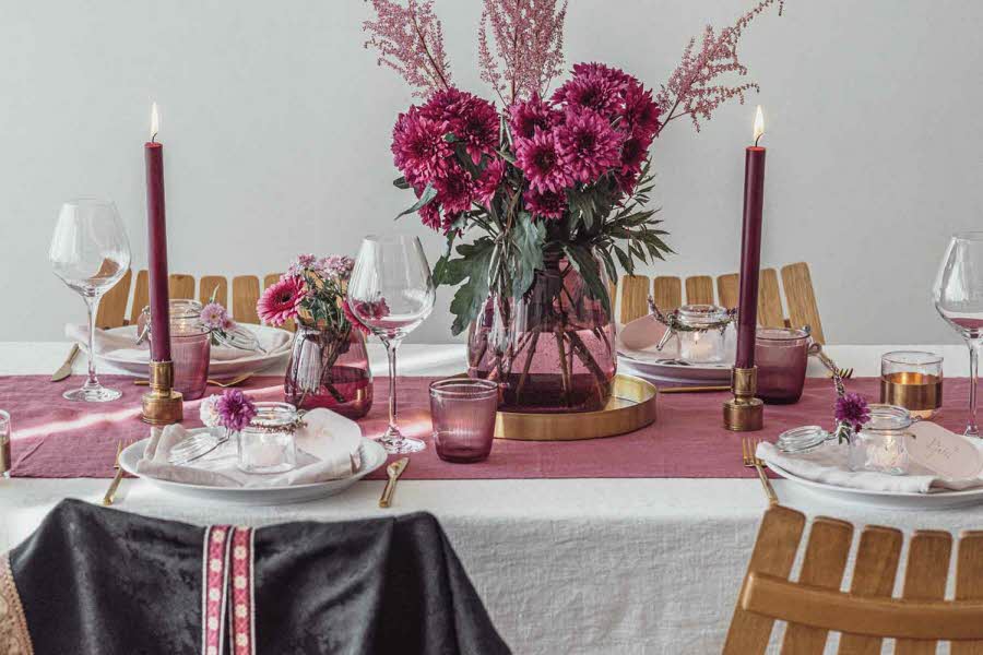 Dekket bord med servise og blomster i rosa