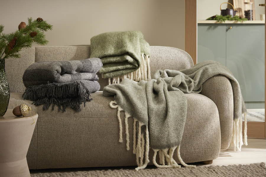 grå sofa med tre pledd