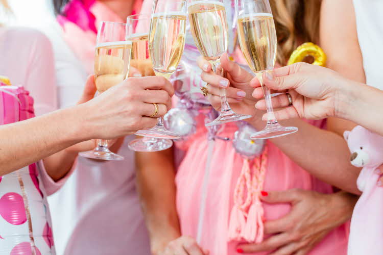 babyshower med damer som holder opp glassene sine med drikke