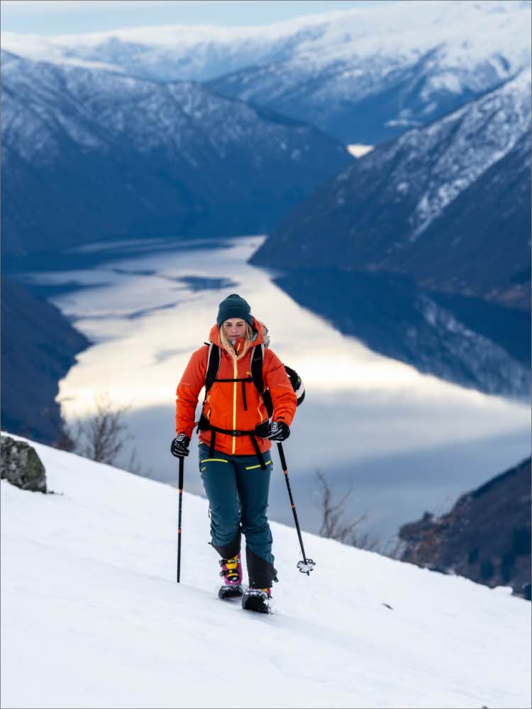 Person på skitur med utsikt over en fjord