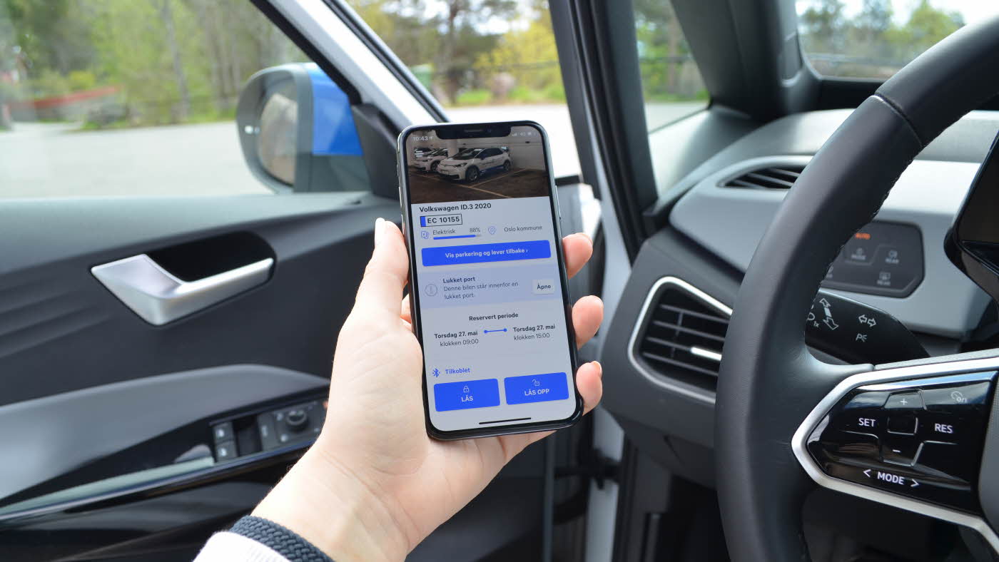 Person som holder en mobil i en bil