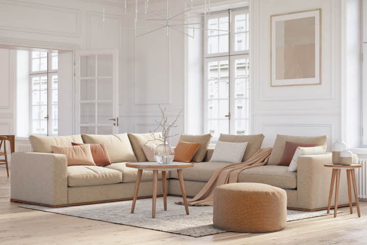 Hvitmalt stue med beige interiør. Sofa, bord, gulvteppe, puff. 