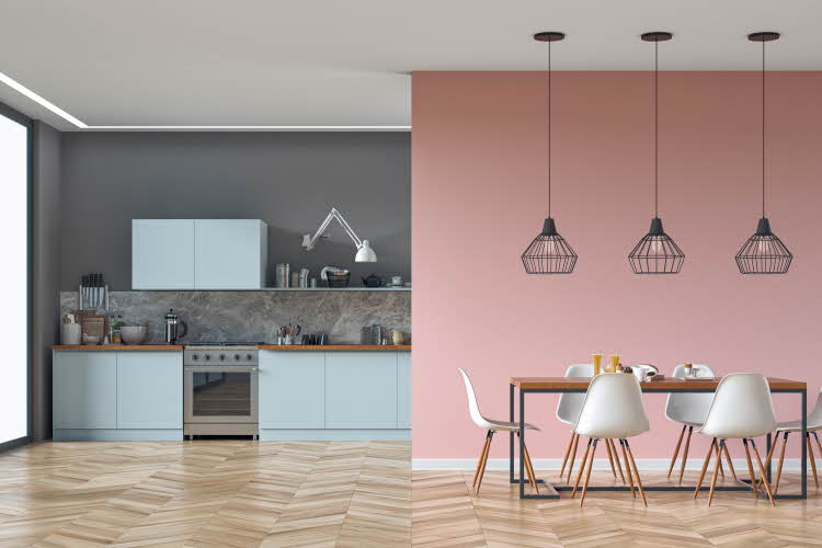 Kjøkken i pastellfarger med lyseblå skap og rosa vegg, tre taklamper, bord og stoler. 