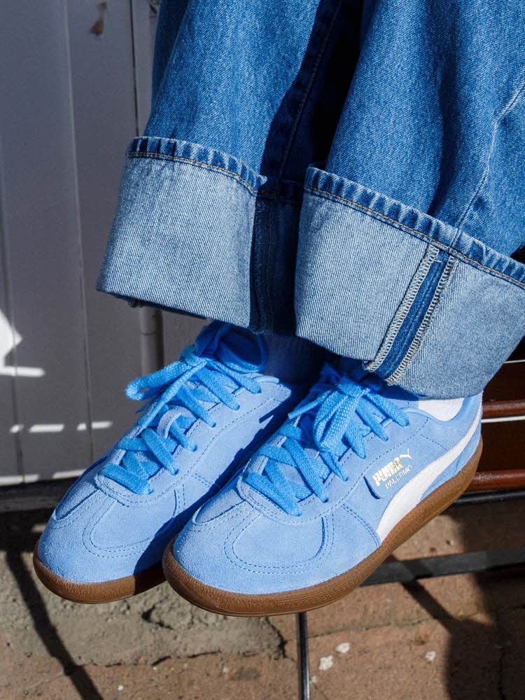 Nærbilde av noen med blå sneakers