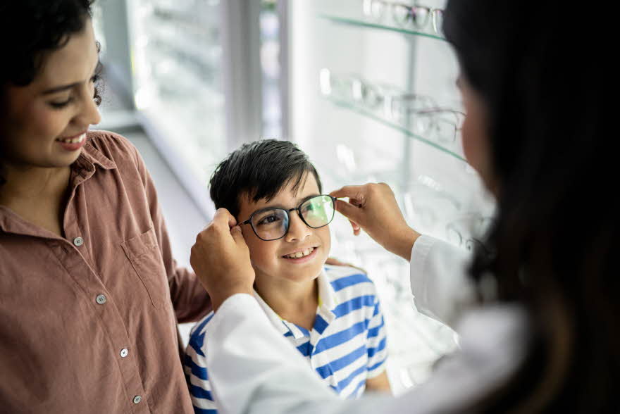 Gutt som får briller tilpasset av en optiker