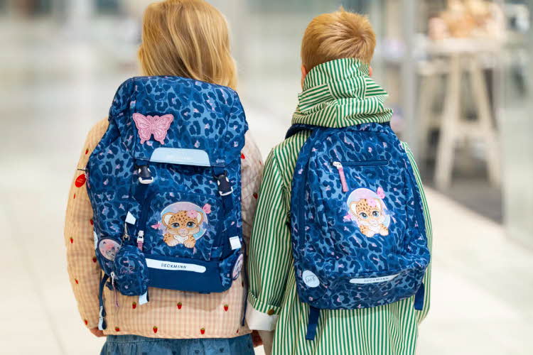 Jente og gutt med ryggen til kamera med blå skolesekker.
