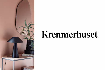 Lampe på et bord og logoen til Kremmerhuset