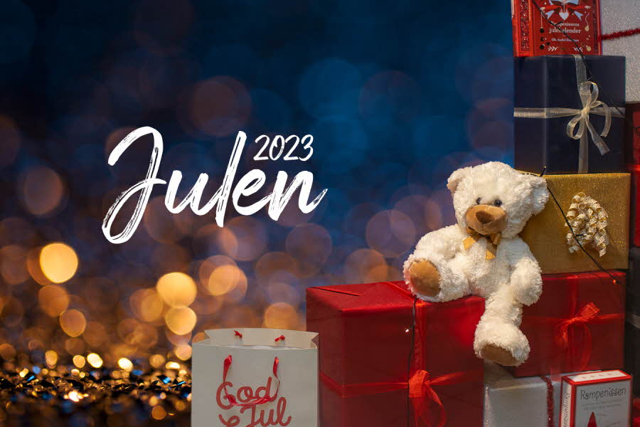 Bamse som sitter på mange pakker og teksten "Julen 2023"
