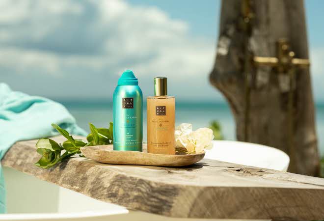 Rituals produkter på en trebenk ved stranden og turkist hav