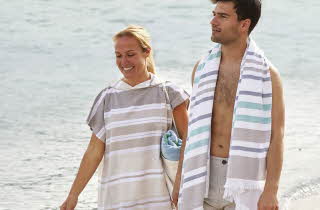 En mann og en kvinne som går på en strand